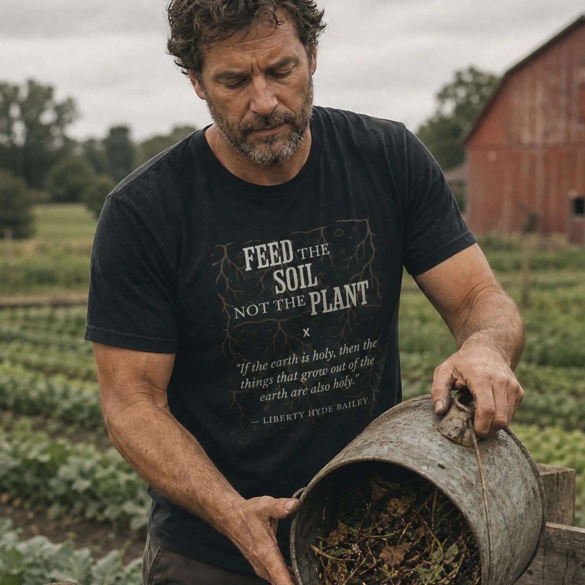 Feed the Soil organic cotton t-shirt worn by man near a composting area on a regenerative farm