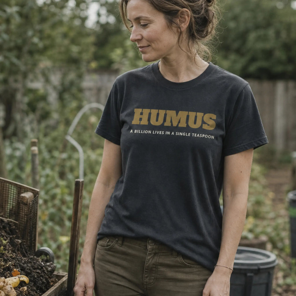 Humus Microbiology organic cotton t-shirt worn by woman in a regenerative garden with rich composted soil