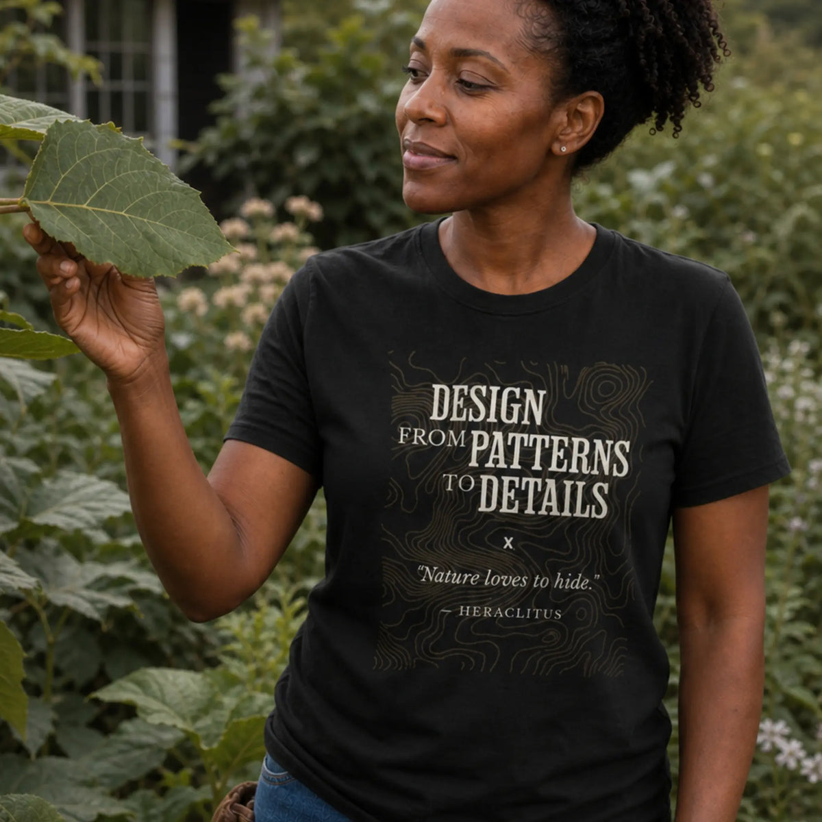 Patterns to Details organic cotton t-shirt worn by woman observing patterns in a diverse permaculture landscape