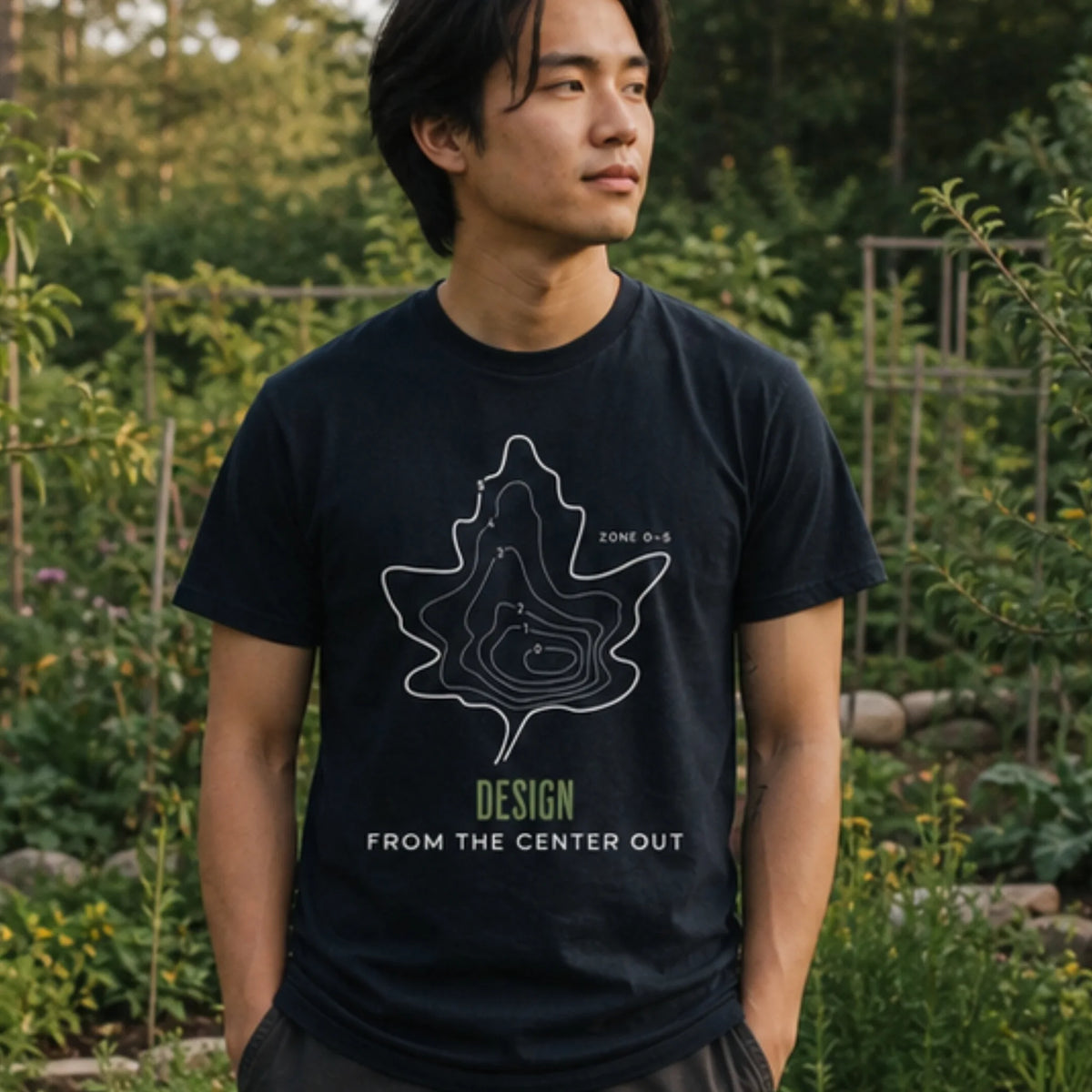 Center Out organic cotton t-shirt worn by man in a permaculture garden designed from the center outward