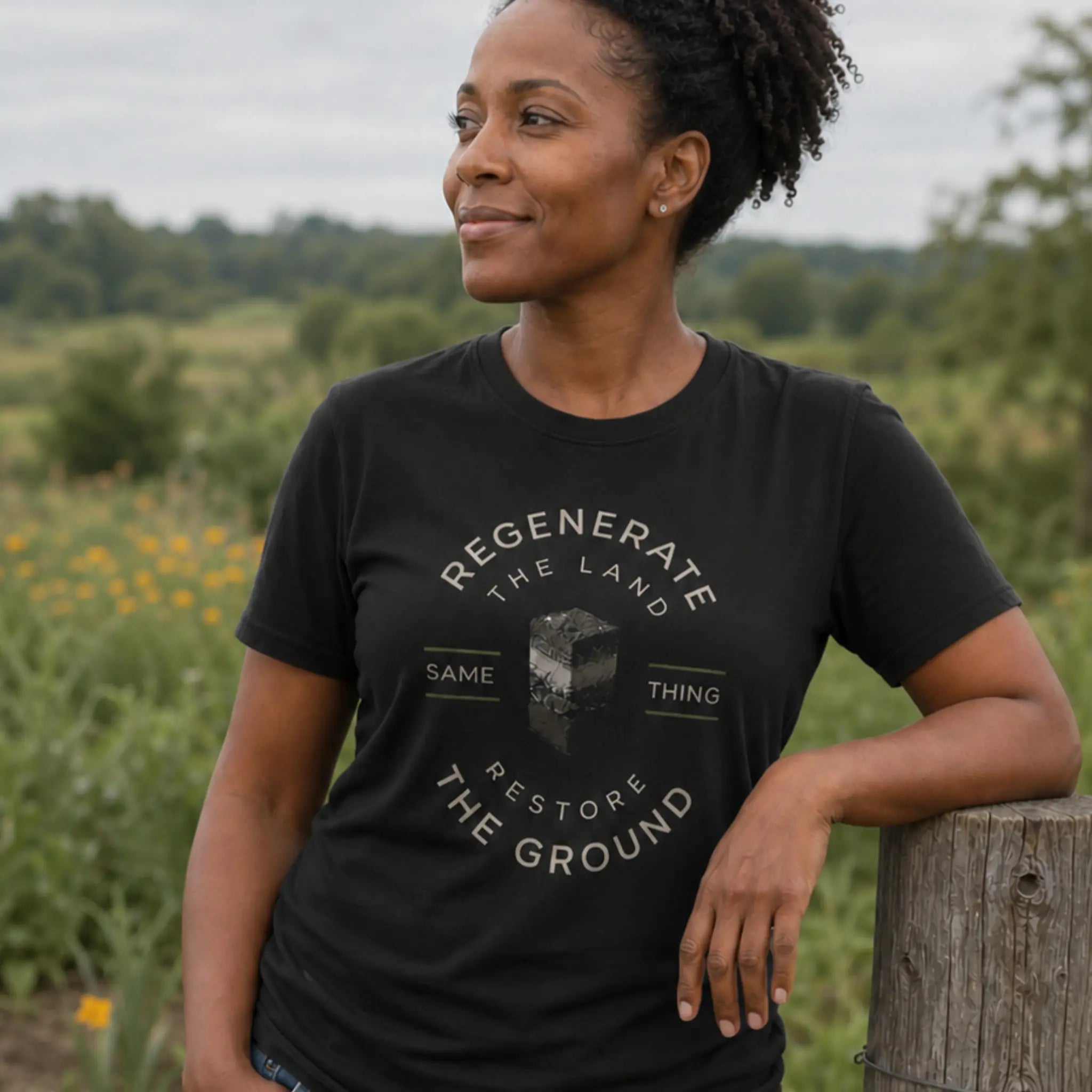 Restore the Ground organic cotton t-shirt worn by woman beside a cover-cropped field on a regenerative farm