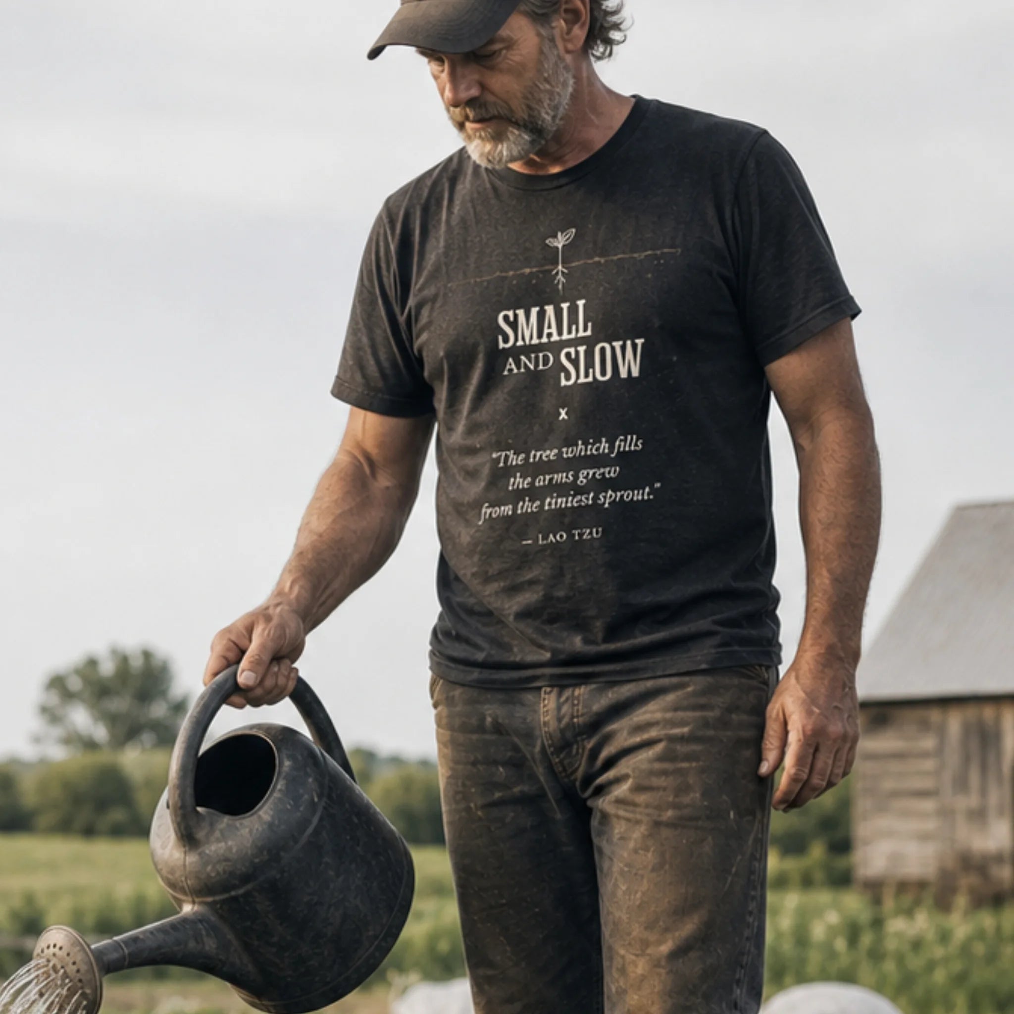 Small and Slow organic cotton t-shirt worn by man in a calm permaculture garden with perennial plantings