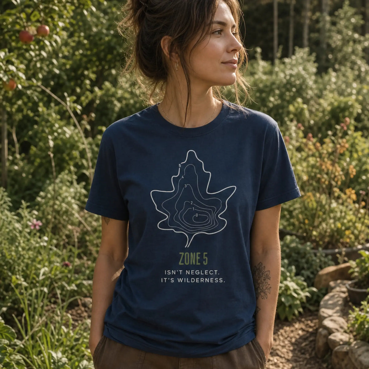 Zone 5 Wilderness organic cotton t-shirt worn by woman at the edge of a permaculture food forest